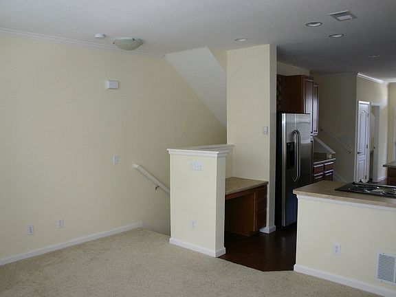 From corner of living room looking at the stairs and kitchen
