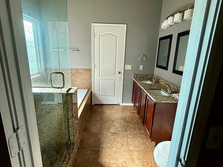 Your bathroom awaits with two vanity sinks, custom tub and glass enclosed walk in shower