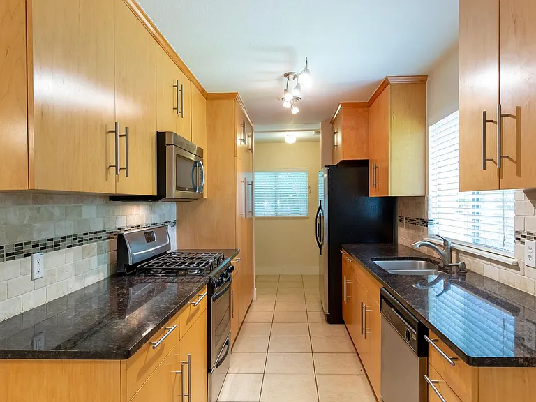 updated kitchen, bright, lots of counter space, and storage, back of photo is washer/dryer and exit to carport