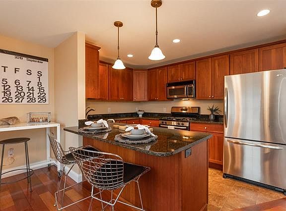 Kitchen with granite counters, steel appliances and breakfast bar.