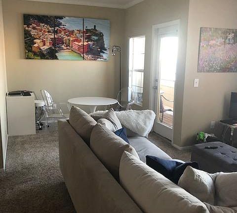 Living and dining area with door to the deck. Windows open for fresh air and have screens.