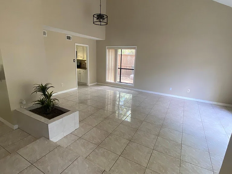 Large living room/dining room with high ceilings and modern black fixtures. new matte black light fixtures