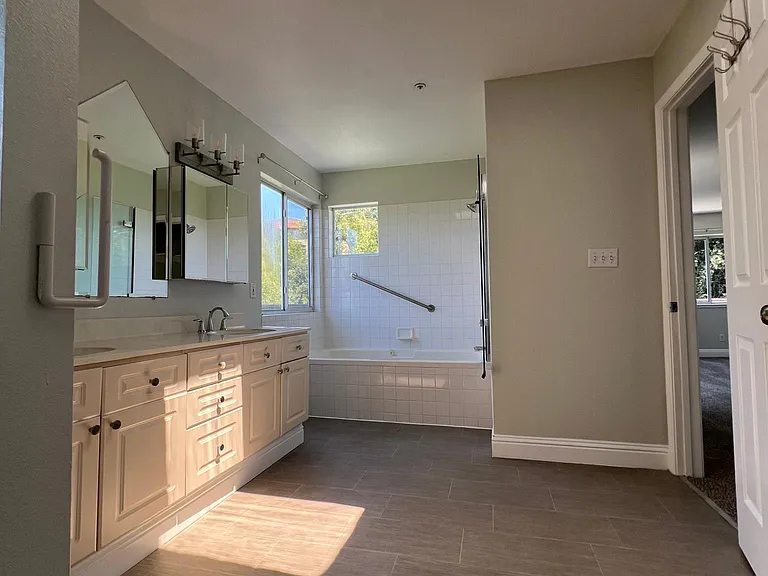 Dual vanity, shower/tub, skylight, toilet, and linen closet in master bath