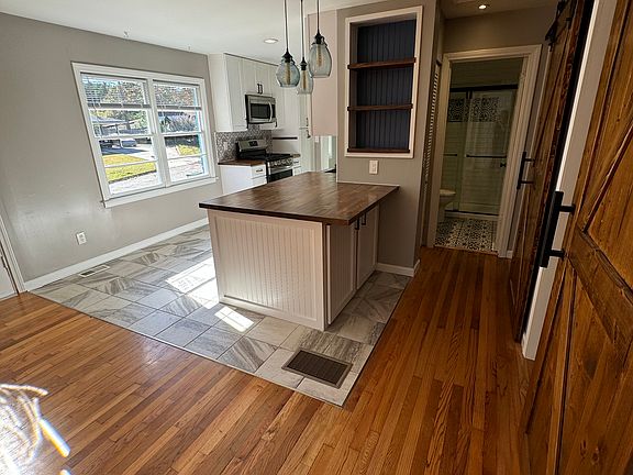 Stunning barn doors serve as a unique focal point, blending rustic charm with modern functionality while custom built-ins offer style and practicality for storage throughout the house.
