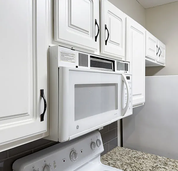 Granite and backsplash surround the stove as well. Microwave to be replaced with a brand new unit.