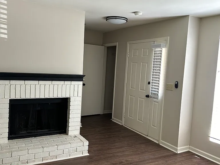 Brick Fireplace in Den with view of the Coat Closet/Storage Area