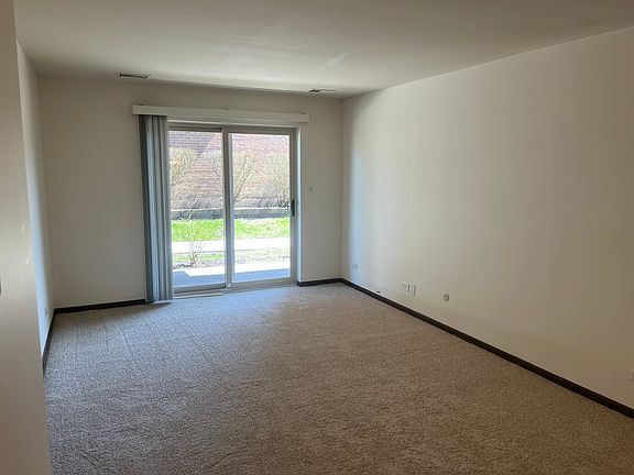 Living Room w new carpet and sliding door to patio