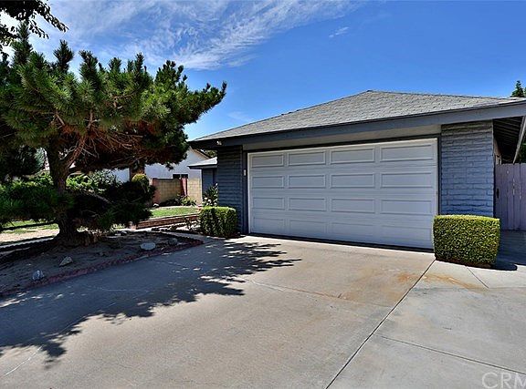 Front of house with mature trees and new electric garage door.