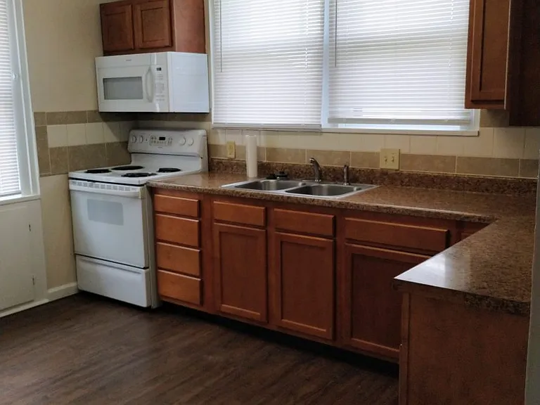 Kitchen has stove, refrigerator, & microwave.3 windows to let the light in.