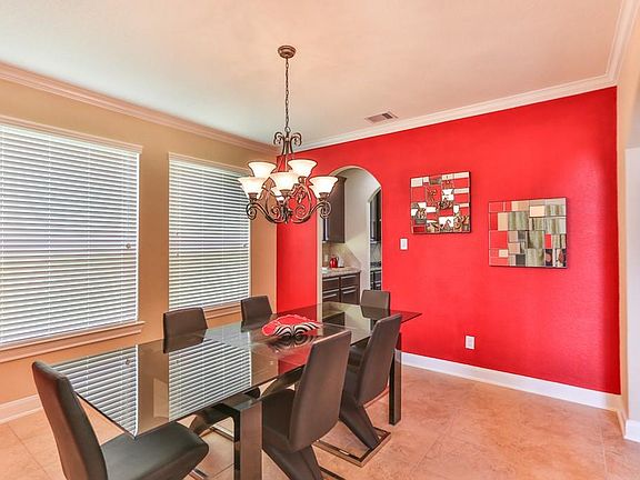 The formal dining room with tile flooring and windows for enhanced natural lighting.