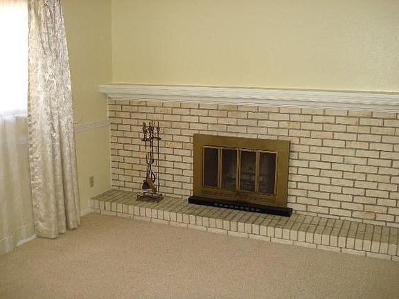 Family room with wood burning fireplace and book shelving
