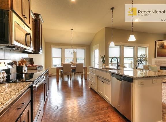 Stainless steel appliances, large island, beautiful hardwood floors in kitchen and dining areal