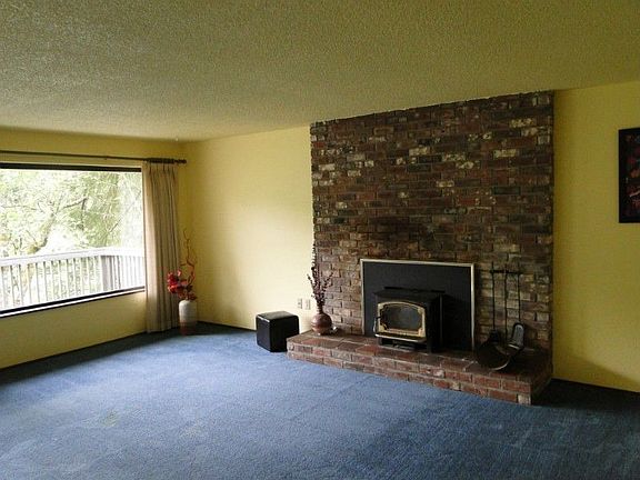 Cozy, wood burning fireplace in the living room. This home is heated by electric furnace and heat pu