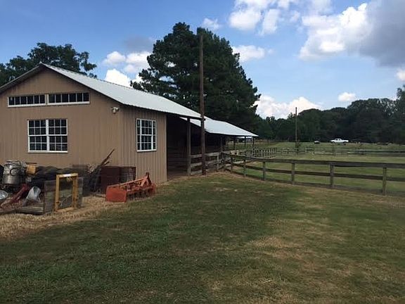 Barn with 4 stalls, 2 hay/tack rooms, and a wash rack