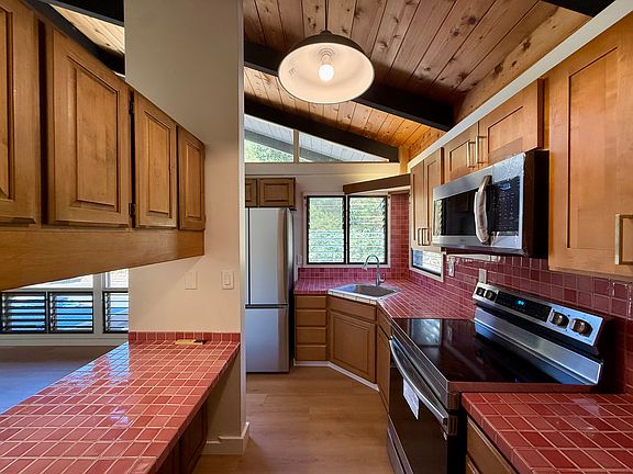 Updated kitchen featuring a brand-new stove, microwave hood, and refrigerator.