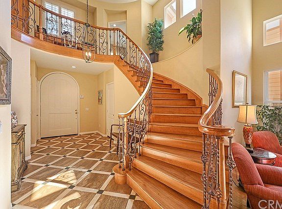 Dramatic formal entry with beautiful iron staircase and stone floors