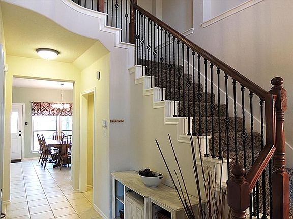 Gorgeous wood and rod iron staircase leads to 4 bedrooms upstairs.