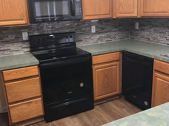large kitchen with new appliances and tile back splash