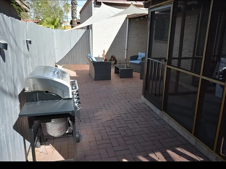 Private outdoor patio area complete with grill and outdoor furniture