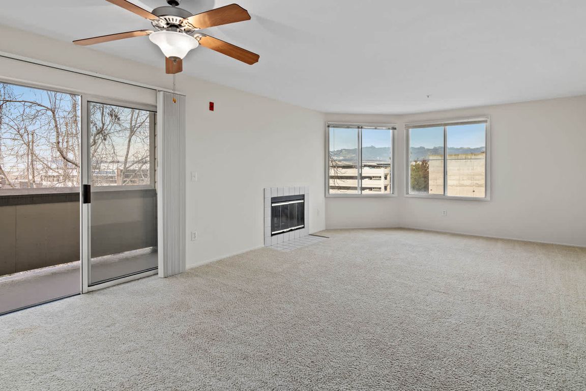 Carpeted Living Room with Fireplace and Balcony