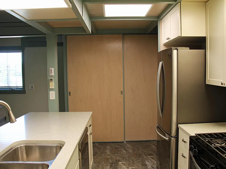 Full kitchen with pantry/storage space beyond.