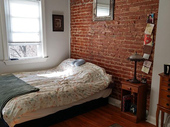 Master bed view, exposed brick wall and vaulted ceiling