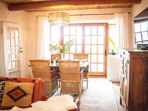 Dining area with sunny deck through sliding doors, and master through door on left side. TV on right.