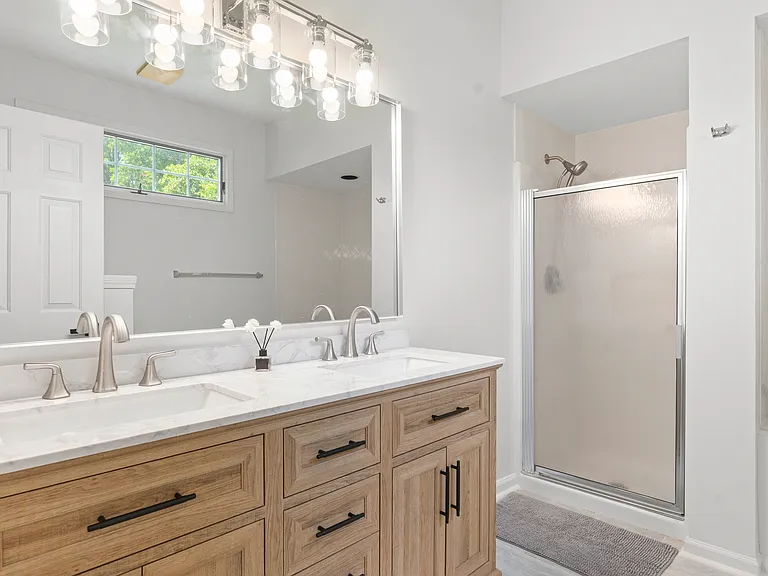 Private primary ensuite bathroom with a double vanity, separate shower, and relaxing Jacuzzi tub.