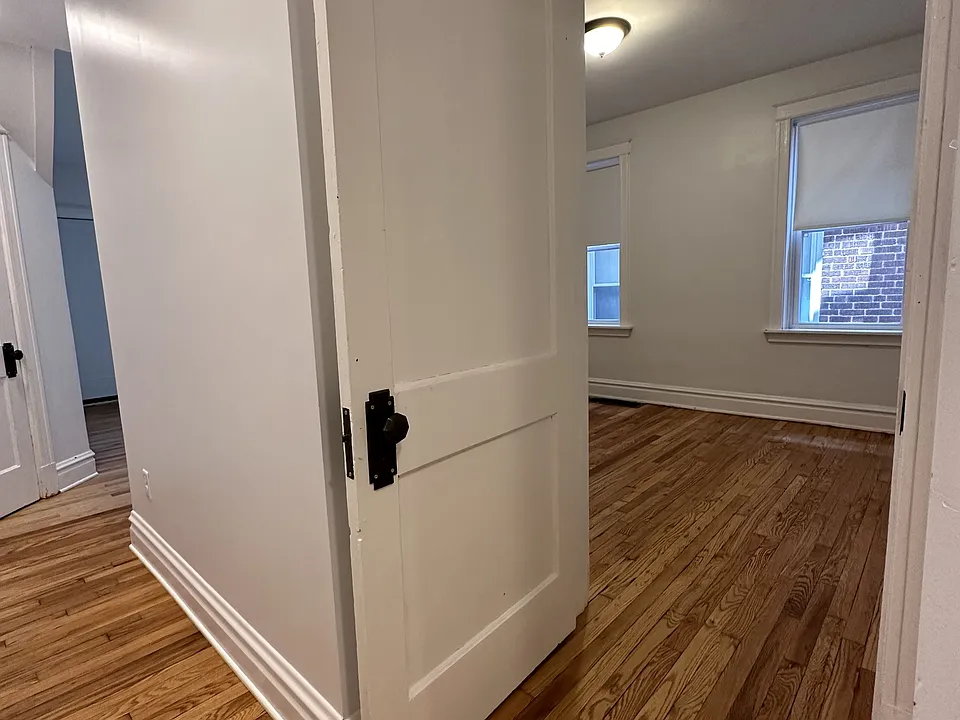 Hallway access into front bedroom. Living room, just out of site, Double paned windows, wood work.