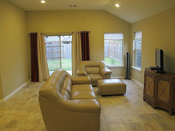Supersized family room with 10-foot ceiling features ceramic tile flooring, recessed lighting, & direct access to the tranquil backyard!