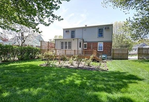 Back of house. Shows additions and dormer, deck, rose garden fencing and deep back yard.