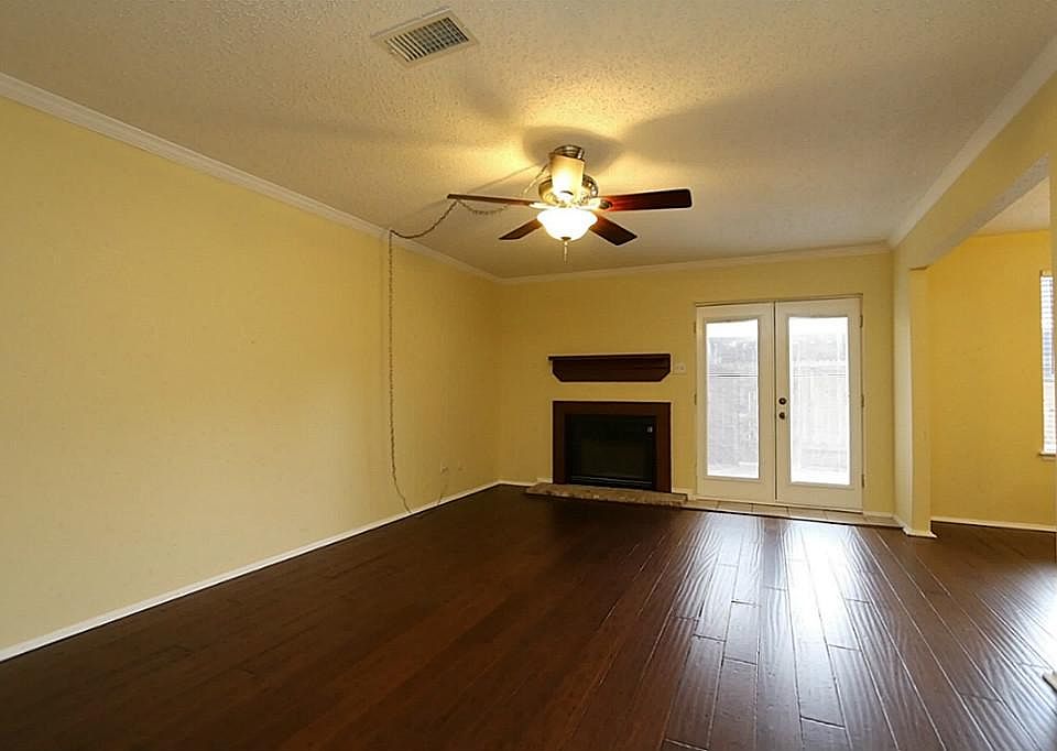Beautiful hardwood floors in living room with ceiling fan an