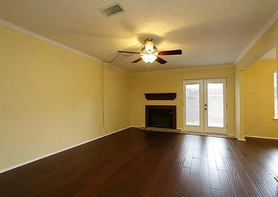 Beautiful hardwood floors in living room with ceiling fan an