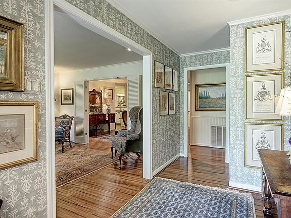 The foyer, lined with designer wall covering, opens into the front living space.