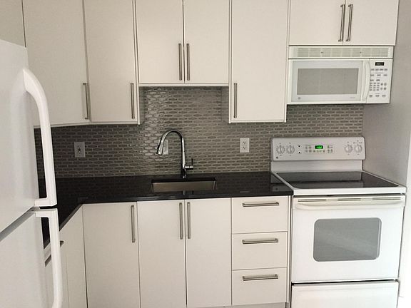 White cabinets with black granite countertop.
