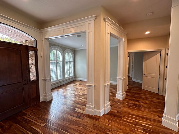 View of main door, family room, and doors leading to primary bedroom.