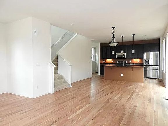 Living Room looking toward kitchen. Hardwood Floors. Stairs leading to 2nd floor.