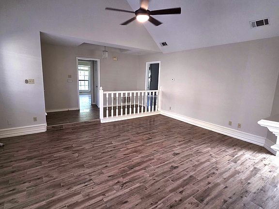 SUPER SPACIOUS LIVING ROOM WITH FIREPLACE, CEILING FANS AND EXPANSIVE WINDOWS.