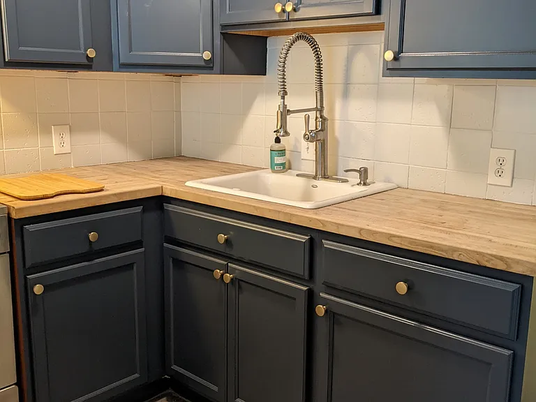 Kitchen with butcher block counters and Kohler pre-wash sprayer nozzle.