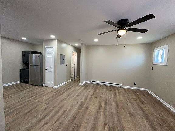 Open living, large ceiling fan, five windows letting in natural light.