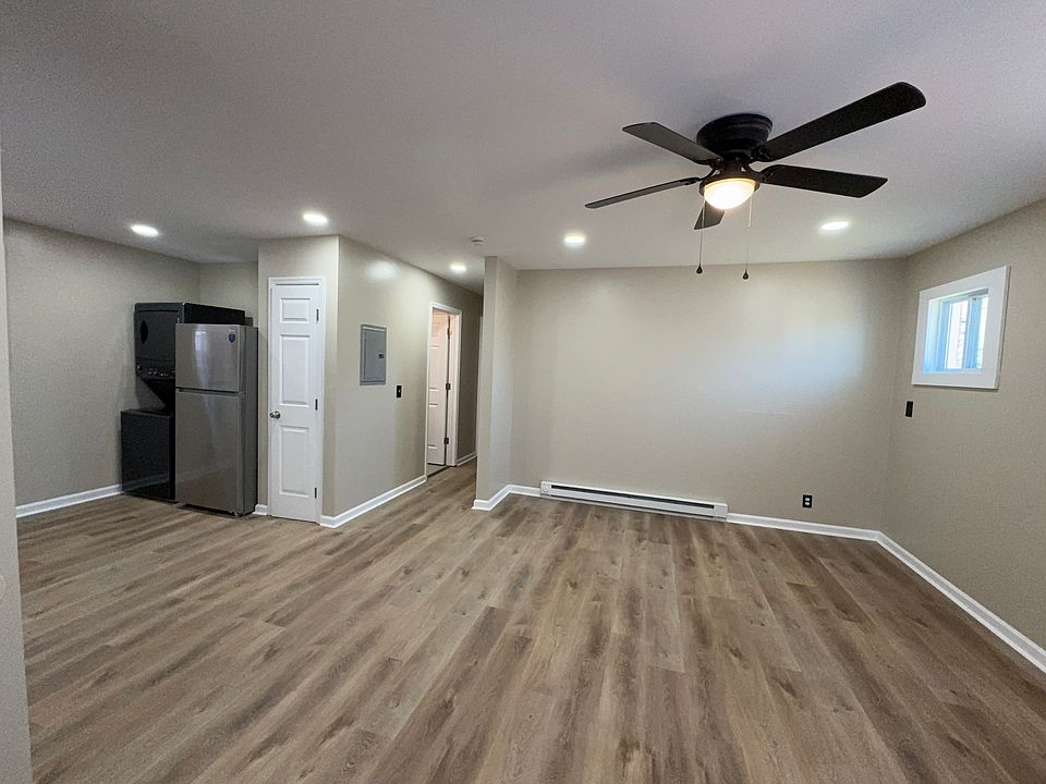 Open living, large ceiling fan, five windows letting in natural light.