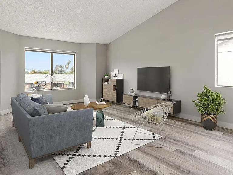 Hardwood floored living room with large windows.