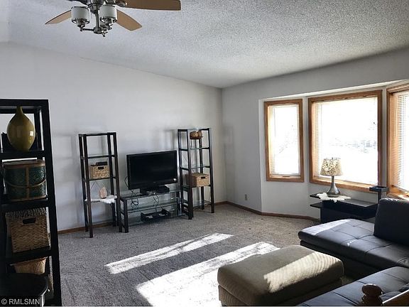 Vaulted living room with bay window and ceiling fan