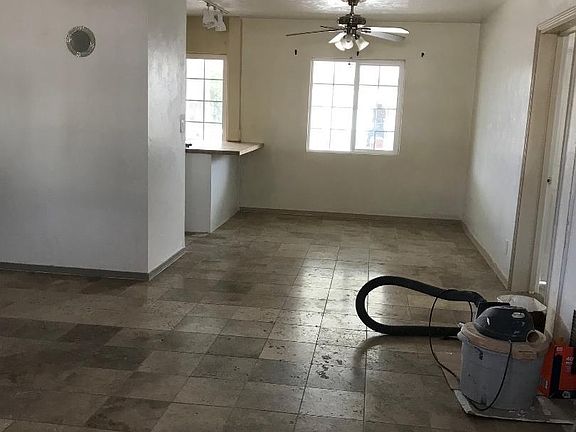 View of living space/dining/kitchen island from front window. Hallway to the left leads to 3 bedrooms and bathroom. Door to the right is entrance to master bdr.