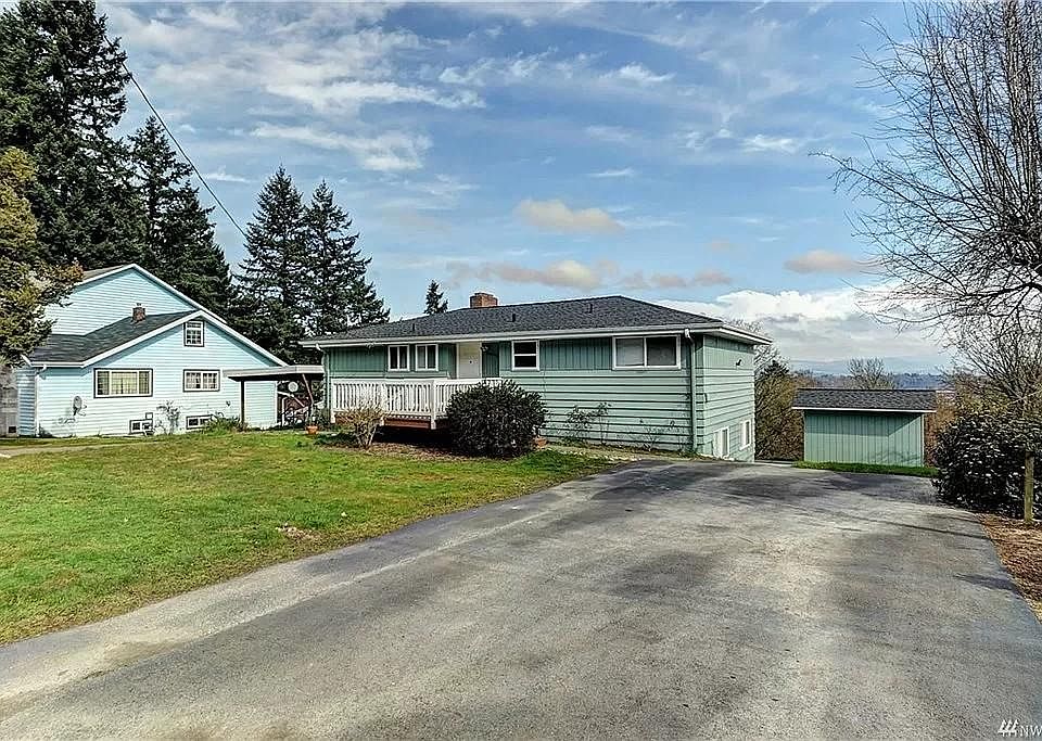 Exterior of home with unit parking and shed to the right.