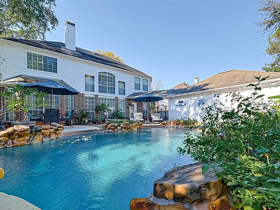 Backyard oasis includes a firepit, heated pool & hot tub! Still yard left over behind the garage - perfect for a dog run, garden or play space.