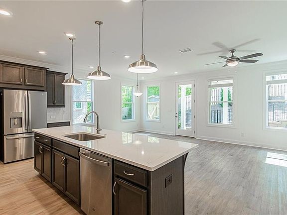 The warm stone design collection has linen colored cabinets, gorgeous quartz countertops with lots o