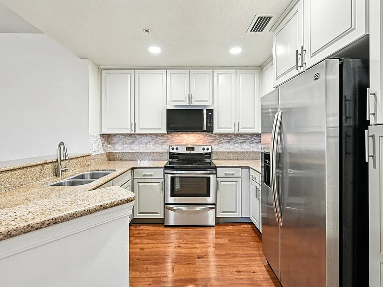 Remodeled kitchen with sleek stainless steel appliances, elegant cabinetry, and polished granite countertops for a stylish cooking experience.