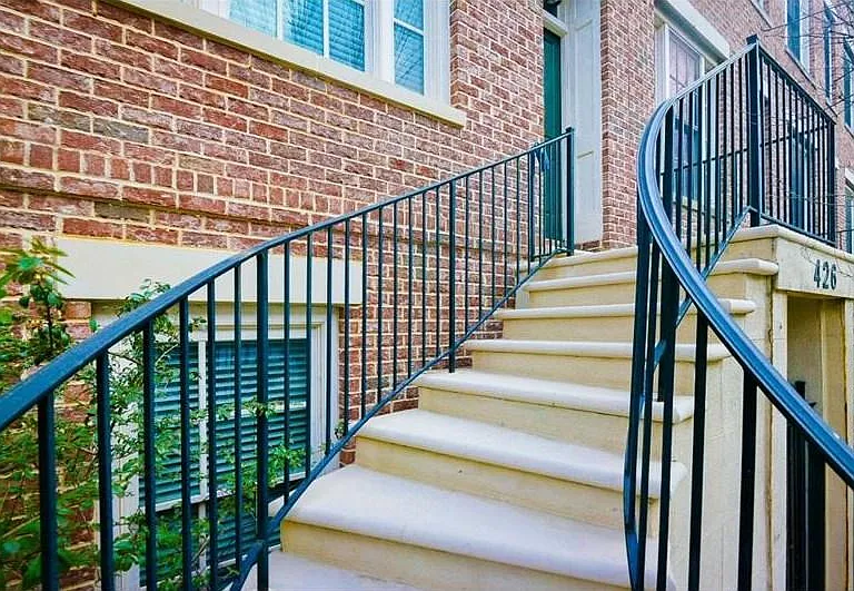 Wrought iron railings leading to a brick facade entrance