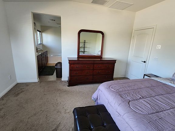 View to the bathroom.
8-drawer dresser with mirror and a end of bed storage bench.